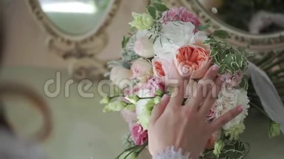 年轻的新娘抚摸新娘的花束视频的预览图