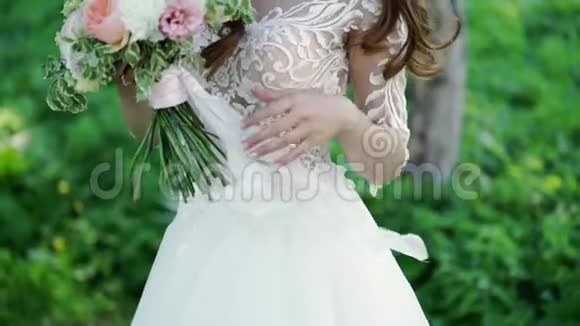 年轻的新娘抚摸新娘的花束视频的预览图