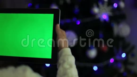 女孩拿着绿色屏幕的平板电脑视频的预览图