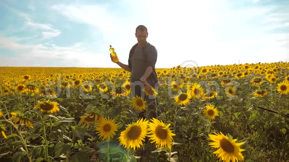 日落时分农夫手捧一瓶葵花籽油农民农业塑料生活方式瓶视频的预览图