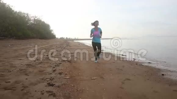 黎明时分黑发女孩在海滩上奔跑视频的预览图