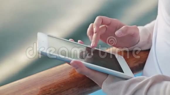 日出时在游轮甲板上使用平板电脑的女人视频的预览图