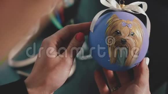 新年装饰球女漆在新年舞会上手画新年球狗在球上的肖像视频的预览图