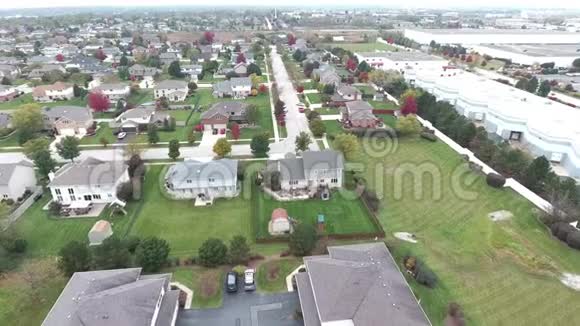 沿着郊区的街道飞过住宅和庭院视频的预览图