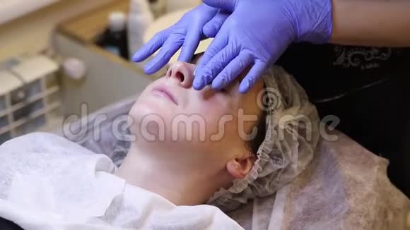 在温泉沙龙接受面部护理的年轻女性视频的预览图
