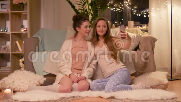 女性朋友在家里用智能手机自拍视频的预览图