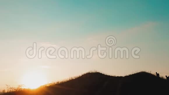 两个男子游客徒步旅行者剪影去山上日落旅游慢动作视频旅行成功的年轻人视频的预览图