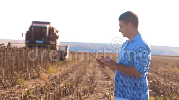 农民工作聪明的农业人阅读或分析收获向日葵一种生活方式报告平板电脑上的农业视频的预览图