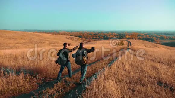 两个背着背包徒步旅行的人正沿着小路爬山慢速视频视频的预览图