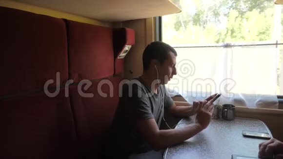 火车车厢上的人剪影听着耳机里的音乐用生活方式的信使写着一条信息视频的预览图