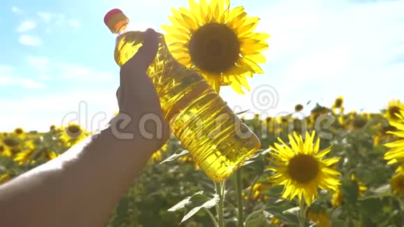 农夫手里拿着生活方式手里拿着一瓶塑料葵花籽油慢动作视频农业视频的预览图