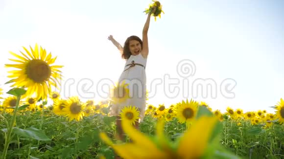 快乐的小女孩生活方式向日葵的田野阳光在夏天美丽的日落小女孩向日葵视频的预览图