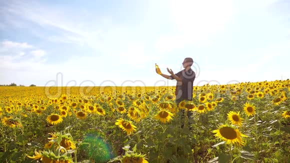 日落时分农夫手捧一瓶葵花籽油男人展示了葵花籽油的生产视频的预览图