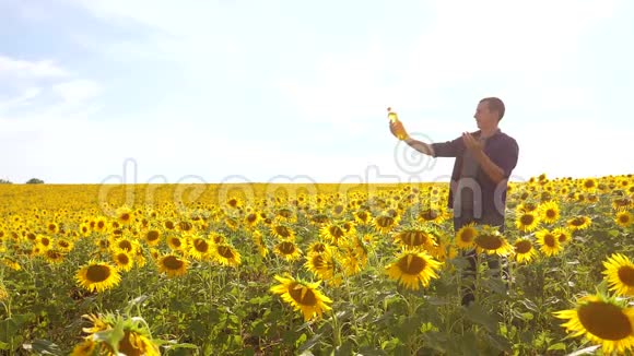 日落时分农夫手捧一瓶葵花籽油男子向日葵生活方式油生产节目视频的预览图