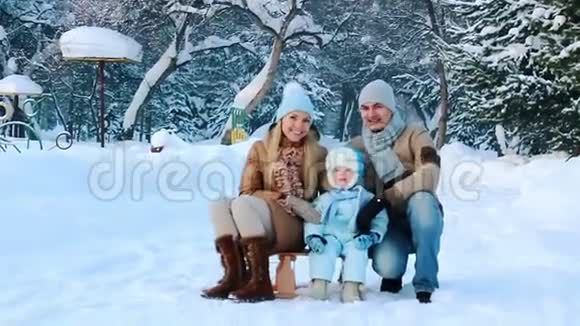 年轻的家庭和他的孩子在冬季公园视频的预览图