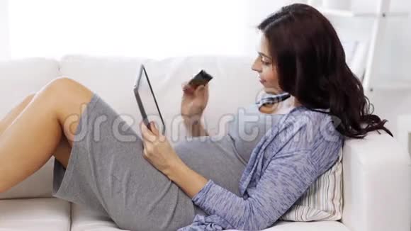有平板电脑和信用卡的孕妇视频的预览图