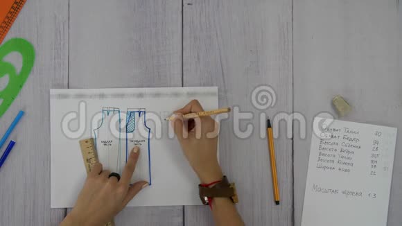 女性的手被画在一种灰色织物缝制裤子的图案上视频的预览图
