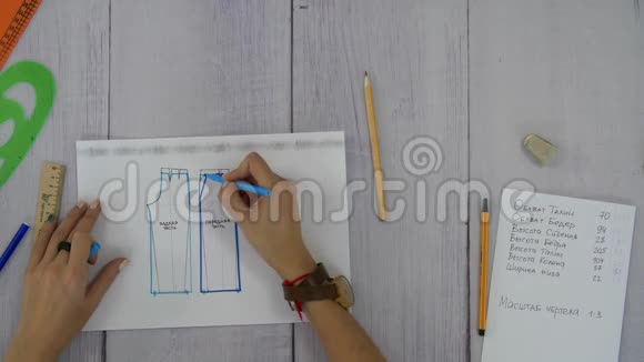 女性的手被画在一种灰色织物缝制裤子的图案上视频的预览图