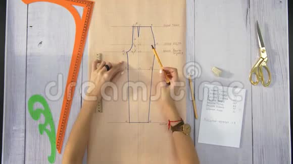 女性用手画一张米黄色纸绣裤子的图视频的预览图