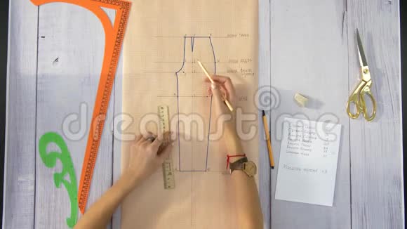 女性用手画一张米黄色纸绣裤子的图视频的预览图
