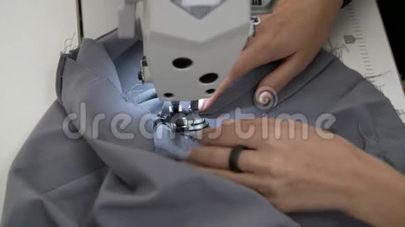 女性的手在缝纫机上缝制灰色织物视频的预览图