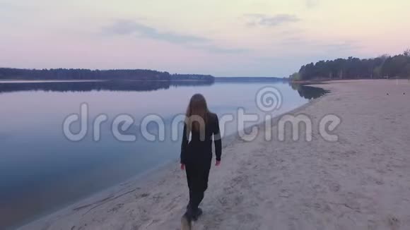 穿黑色衣服的女孩在日出的海滩上奔跑视频的预览图