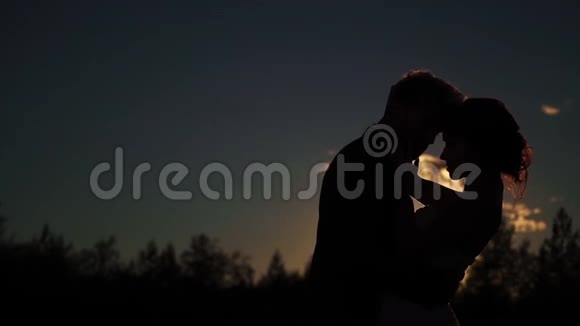 年轻可爱的情侣拥抱剪影视频的预览图
