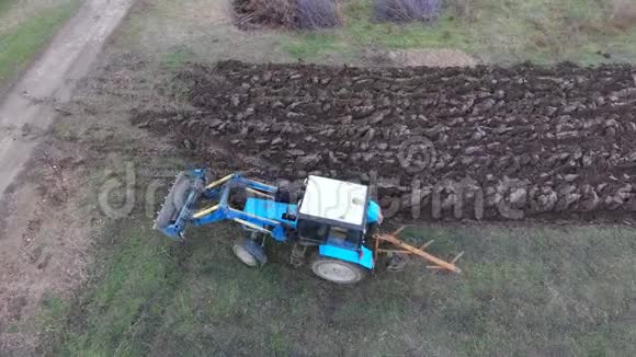 拖拉机犁花园使土壤在田间流动视频的预览图