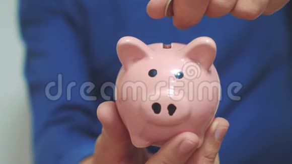 商人制造储蓄把硬币放在储蓄罐里猪银行的经营理念慢动作录像省钱视频的预览图