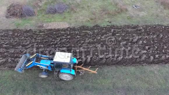 拖拉机犁花园使土壤在田间流动视频的预览图