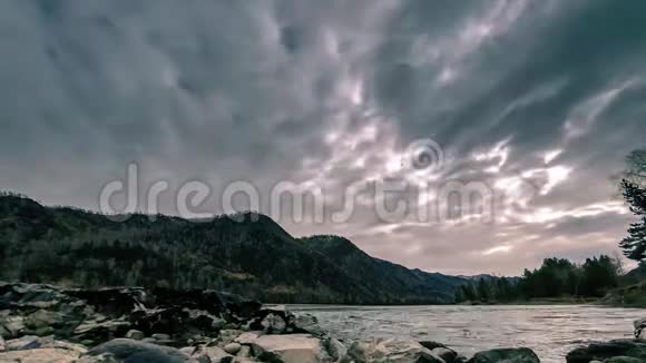 山林附近一条河流的时间流逝巨大的岩石和快速的云层移动水平滑块运动视频的预览图