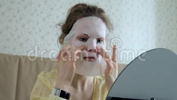 在家中的厨房里一个正在做面膜面罩面膜的年轻女人视频的预览图