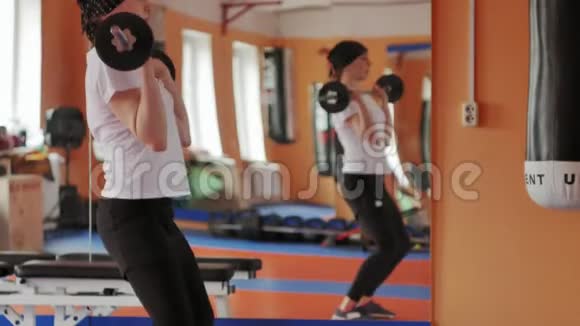 女子跆拳道是在一个有杠铃的体育工作室里训练的视频的预览图