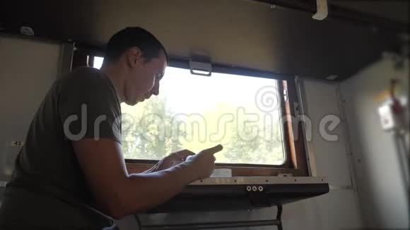这个人的生活方式是坐在火车车厢上拿着智能手机喝着咖啡和茶慢动作视频的预览图