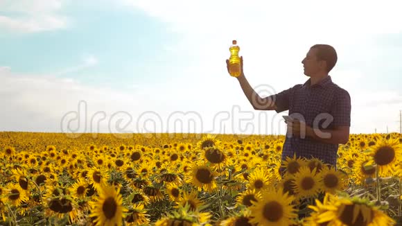 农夫用向日葵在田野里探索慢动作视频生活方式男人农夫手拿生活方式瓶视频的预览图