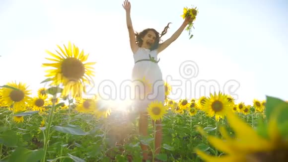 夏天向日葵阳光的田野生活方式上快乐的小女孩美丽的日落小女孩向日葵视频的预览图