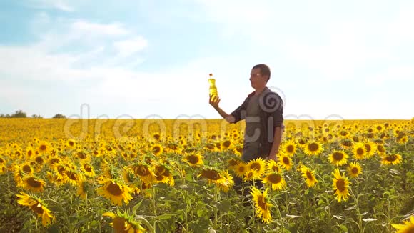 日落时分农夫手捧一瓶葵花籽油生活方式慢动作视频农民农业视频的预览图