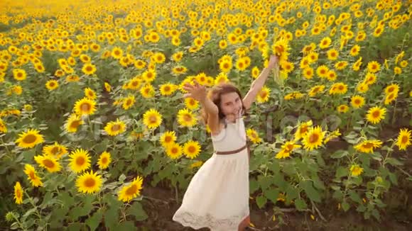 夏天向日葵田野上快乐的小女孩美丽的小女孩生活方式向日葵慢速视频视频的预览图