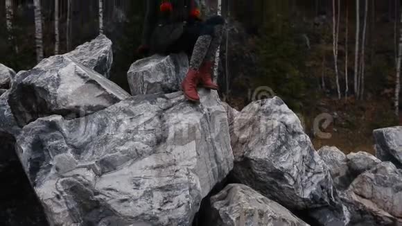 艺术家女孩画坐在悬崖的岩石上记事本奇妙的瀑布景观视频的预览图