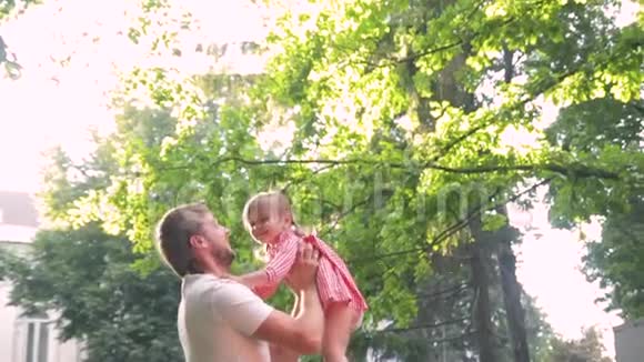 年轻幸福的家庭和小美丽的婴儿蓝色的眼睛走在夏季公园日落视频的预览图
