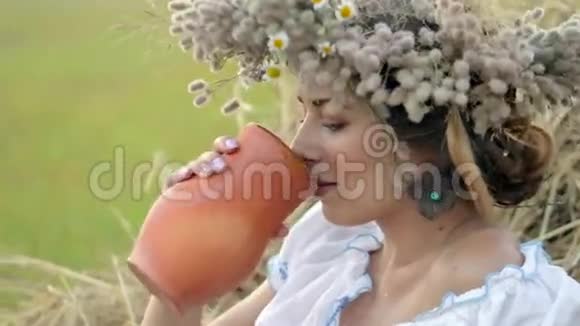 年轻漂亮的女孩正在用水壶喝牛奶视频的预览图