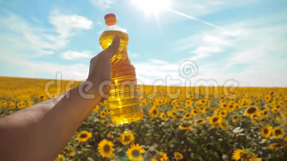 慢动作录像日落时分农夫手捧一瓶葵花籽油农民生活方式农业视频的预览图