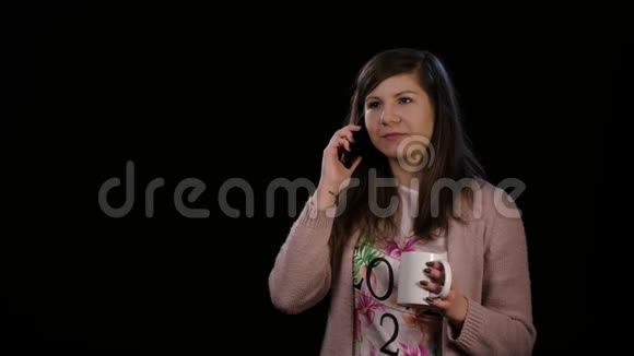 黑色背景下使用电话的快乐女士视频的预览图