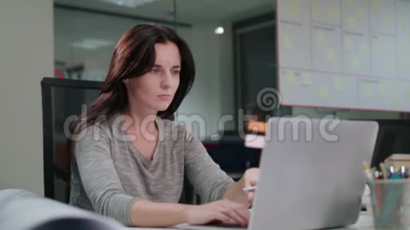 一位女士坐在办公室里用笔记本电脑工作视频的预览图