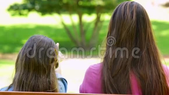 母女俩坐在公园的长椅上视频的预览图