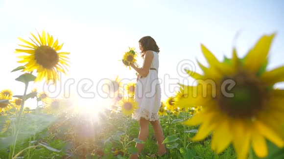 快乐的小女孩在向日葵领域阳光的生活方式在夏天美丽的日落小女孩向日葵视频的预览图