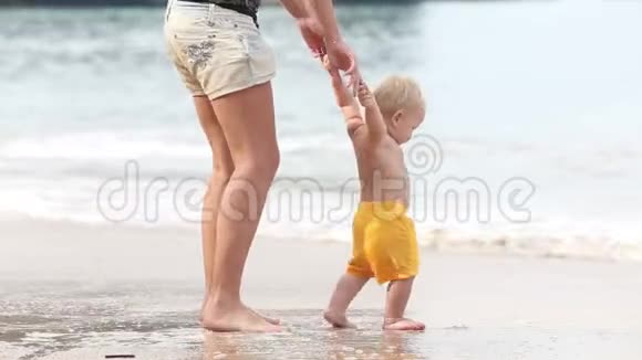 孩子在海滩上和他妈妈一起经过把手视频的预览图