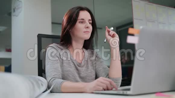 一位女士坐在办公室里用笔记本电脑工作视频的预览图