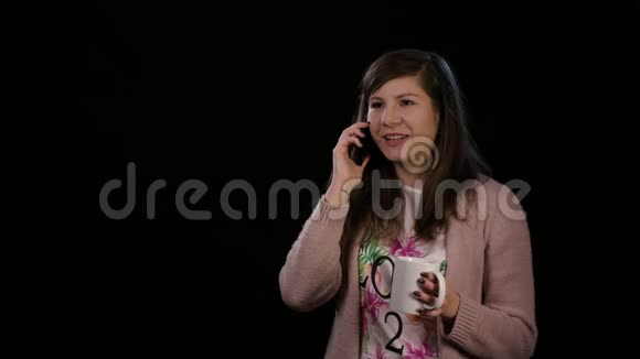 快乐的女士在黑色背景下使用电话视频的预览图