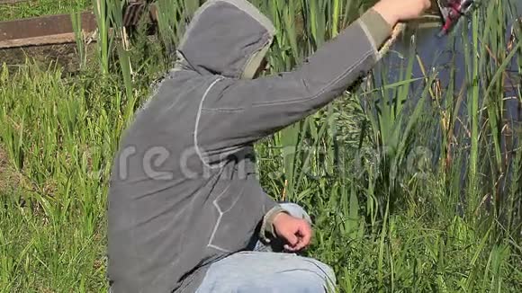 带着鱼竿的人在湖边视频的预览图